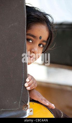 Heureux jeunes pauvres caste inférieure Indian street fille jouant à l'intérieur d'un rickshaw indien. Selective focus Banque D'Images