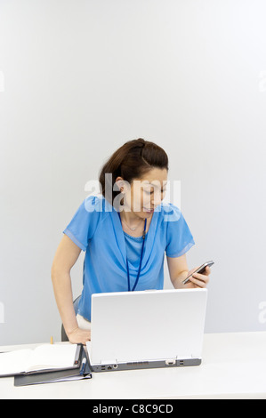 Mid adult woman in d'affaires décontractée à la surprise et Smartphone Banque D'Images