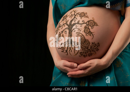 Une photo couleur de henné un 'arbre de vie' design sur une femme enceinte du ventre. Banque D'Images