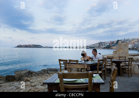 Couple sitting at waterfront cafe Banque D'Images