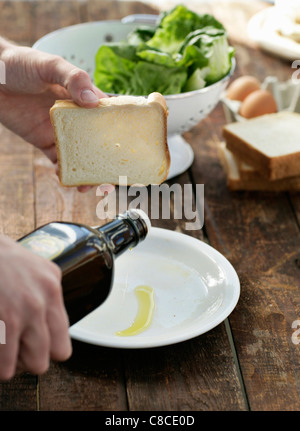 Man pouring olive oil sur la plaque Banque D'Images