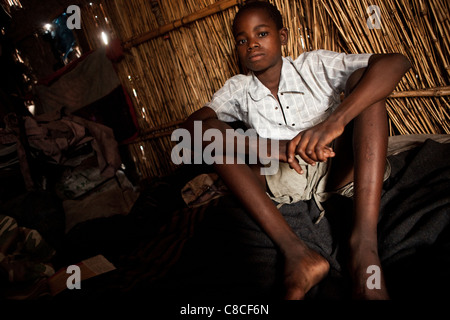 Un enfant est assis seul dans une hutte de Mongu, Zambie, Afrique du Sud. Banque D'Images