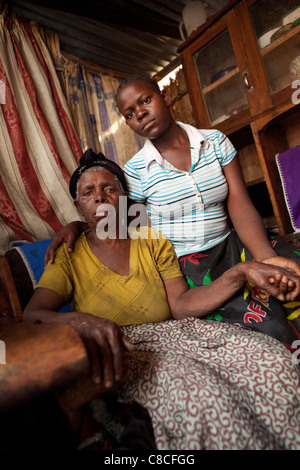 Un adolescent orphelin est assis avec sa grand-mère dans leur maison de Mongu Zambie. Banque D'Images