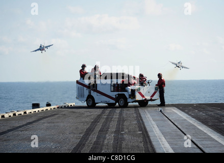 Stand de marins d'envol d'incendie qu'un F/A-18C Hornet affectés à l'Escadron de chasse de grève Warhawks (VFA) 97 lance Banque D'Images