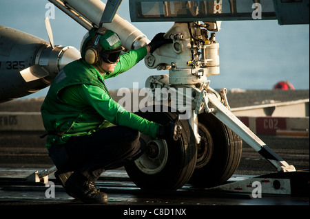 Effectuer un contrôle final sur un F/A-18E Super Hornet affectés à l'Tophatters à bord du porte-avions USS John C. Stennis Banque D'Images