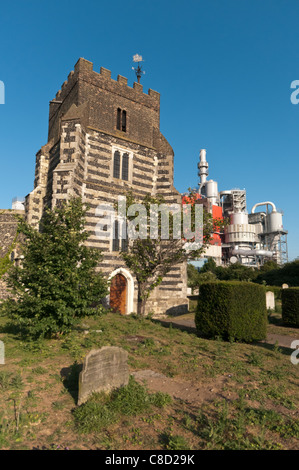 Église St Clements, Thurrock, Essex, Royaume-Uni dominé par une usine adjacente. Banque D'Images