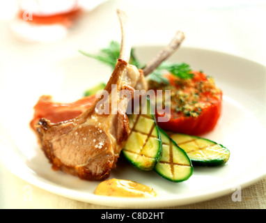 Les côtelettes d'agneau avec des tomates grillées et courgettes Banque D'Images