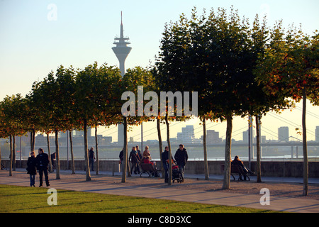 Promenade le long de la rivière Rhin. Les gens de s'asseoir et de marcher le long des rives, de la vieille ville de Düsseldorf, Allemagne. Banque D'Images