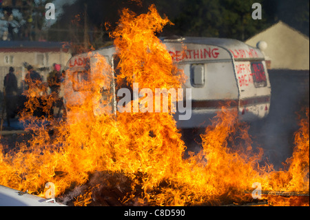 Un incendie en brûlant avant d'une caravane qui a été peint avec des slogans de protestation au cours de l'expulsion de Dale Farm dans l'Essex. Banque D'Images