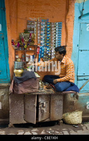 L'homme indien exécute market stall dans ruelle de la ville de Varanasi, Benares, Inde du Nord Banque D'Images