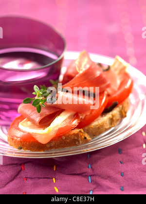 La tomate, fromage et jambon cru sur le pain coupé en tranches. Banque D'Images