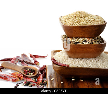 Assortiment de riz dans des bols en bois sur fond blanc Banque D'Images