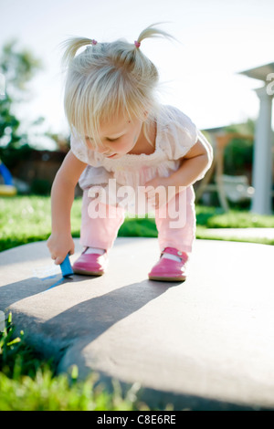 Bébé fille écrit sur un sol de craie de trottoir Banque D'Images