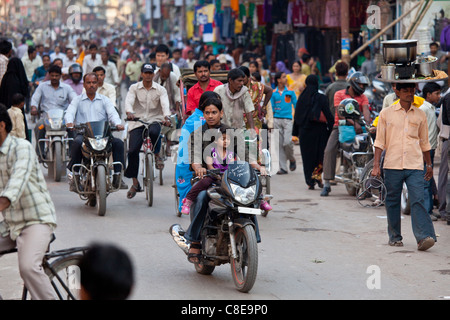 Père avec enfant sur une moto dans la rue bondée pendant le Festival de Shivaratri en sainte ville de Varanasi, Inde Banque D'Images