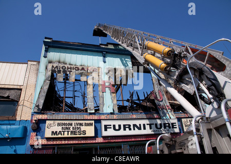 Plate-forme aérienne déverser de l'eau sur les suites de l'incendie criminel incendie pour les bâtiments commerciaux à Highland Park, près de Detroit Michigan USA Banque D'Images