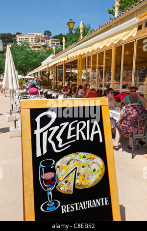 Restaurant pizzeria en plein air avec les visiteurs appréciant le déjeuner sur la terrasse ensoleillée en Port de Soller Majorque Espagne Banque D'Images