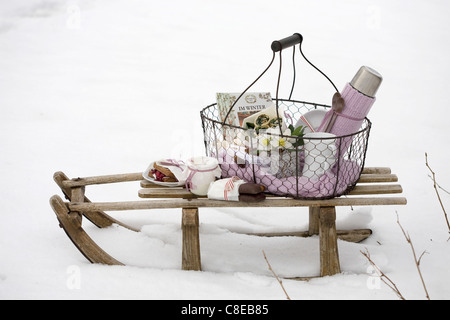 Panier pique-nique sur un traîneau dans la neige Banque D'Images