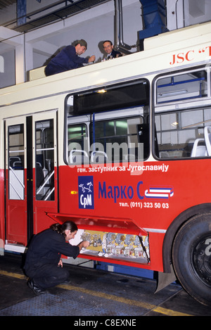 Belgrade, Serbie, Yougoslavie. Dépôt d'autobus ; l'homme de faire un contrôle technique sur un bus rouge. Banque D'Images