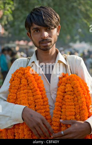 Jeune homme vente de guirlandes de fleurs à Delhi matin marché aux fleurs, Connaught Place, New Delhi, Inde Banque D'Images