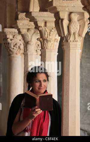 Femme lisant la Bible dans le Cloître de Saint Sauveur, Aix en Provence, Bouches du Rhône, Provence, France Banque D'Images