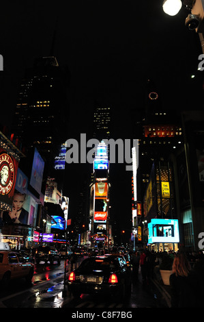 Portrait de nuit Pluie ciel noir lumière rouge voitures, les gens, le néon panneaux publicitaires, Roi Lion théâtre, 7ème Avenue, Times Square, New York Banque D'Images