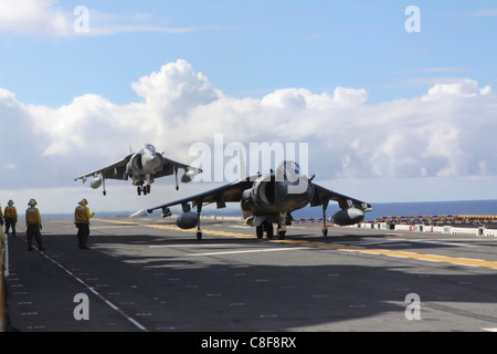 Comme l'un AV-8B Harrier se prépare pour le décollage (premier plan), l'autre exécute un atterrissage vertical sur l'envol du USS Essex, Banque D'Images