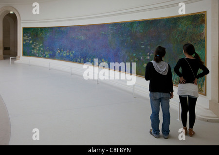 Deux jeunes femmes admirer des Nymphéas de Claude Monet, Musée de l'Orangerie Musée, Paris, France Banque D'Images