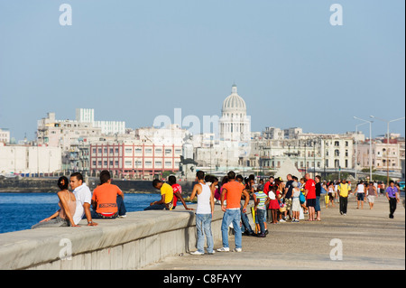 Les gens qui marchent sur le Malecon, Capitolio et toits de la ville, La Havane, Cuba, Antilles, Caraïbes, Amérique Centrale Banque D'Images