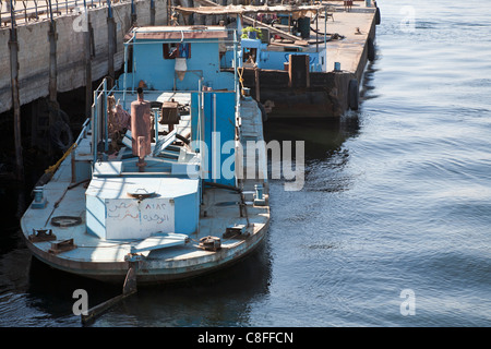 En regardant légèrement vers le bas sur un remorqueur de bateau amarré à la jetée de l'appareil photo face arrière avec reflet dans l'eau calme, du Nil Egypte Banque D'Images