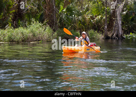 Jeune femme en kayak Kayak orange sur la rivière d'argent près de Silver Springs State Park à Ocala en Floride Banque D'Images