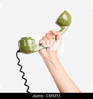 La tenue d'une main de femme casque vert à partir d'un téléphone vintage Banque D'Images