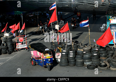 Tuk Tuk en face de Barricade faite de pneus & poteaux de bambou, Red shirt protestation, Bangkok, Thaïlande Banque D'Images