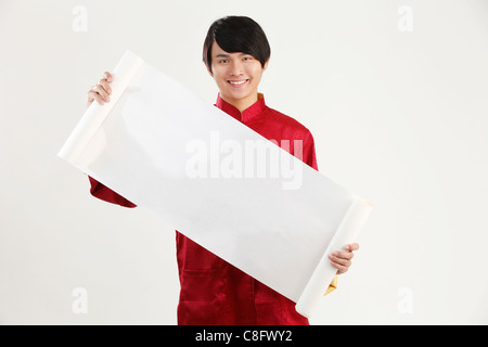 L'homme en habits traditionnels chinois holding blank banner Banque D'Images