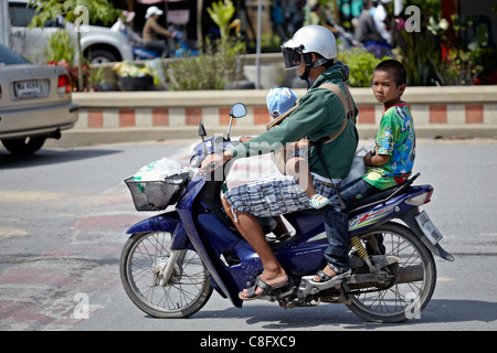 Précairement mère portant son enfant sur une moto. Elle porte un casque mais les enfants ne sont pas. Thaïlande Banque D'Images