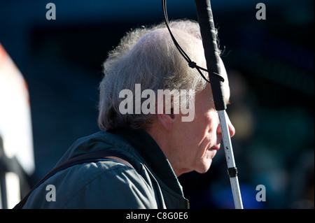 Un aveugle assis holding white stick lors de l'écoute de discours à rallye plus durement touchés à Londres, une protestation contre les coupures à DLA. Banque D'Images