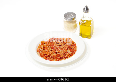 Spaghetti de blé entier cuit dans un bol blanc avec des condiments d'huile d'olive et parmesan râpé sur fond blanc. Banque D'Images