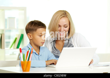 Portrait of pretty tutor et son élève travaillant avec un ordinateur portable Banque D'Images