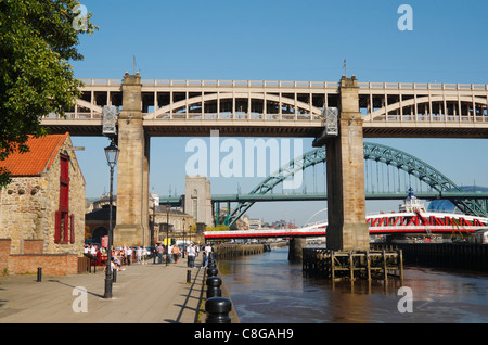 Les gens de l'extérieur du quai neat Pub le haut niveau route/rail bridge sur Newcastle Quayside, Newcastle upon Tyne, Angleterre Banque D'Images