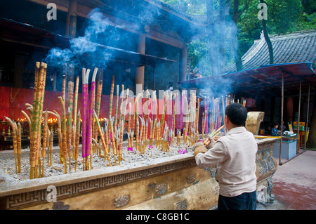 Bâtonnets d'encens brûlant dans un monastère au-dessus le bouddha géant de Leshan, Sichuan, Chine Banque D'Images