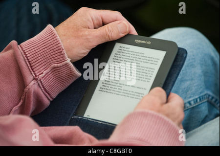Man reading book sur Amazon Kindle ebook reader Banque D'Images