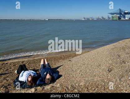 Deux personnes se trouvant sur la plage de Landguard Point Banque D'Images