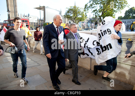 Vince Cable, le secrétaire d'entreprise, est confrontée par des manifestants opposés à la "l'évasion fiscale de l'entreprise' pendant qu'il marche de Whitehall à Victoria Street, dans le centre de Londres, Royaume-Uni, le lundi 24 octobre, 2011. Banque D'Images