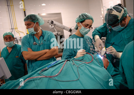 Médecins pratiquant la chirurgie dans la salle d'exploitation Banque D'Images