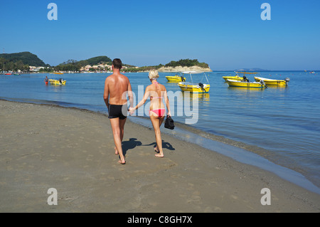 Jeune couple marche main dans la main le long de la plage de Sidari, Corfou, Grèce, vers l'attraction touristique de Canal D'Amour Banque D'Images