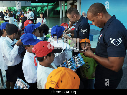 Sergent d'état-major Chris McClure (à gauche) et le sergent d'état-major. Anthony Stewart visite avec des enfants de l'école malaisienne le 1er octobre 2009, à Kuala Lumpur, en Malaisie. L'escadron de démonstration aérienne de la US Air Force, les Thunderbirds, a participé à l'exposition aérienne malaisienne. Banque D'Images