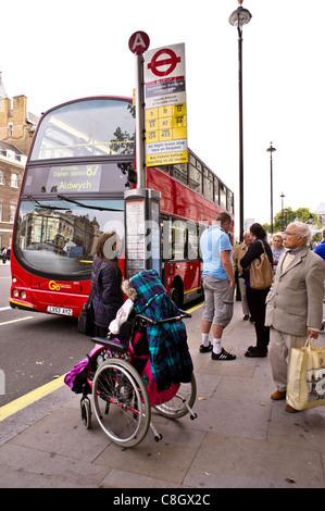 Un passager à mobilité réduite attend un bus de Londres Banque D'Images