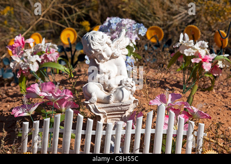 Angel et de fleurs et de petits clôture blanche sur une tombe d'une petite fille. Old Pioneer et mauvaises herbes négligé fort Duchesne cimetière. Banque D'Images