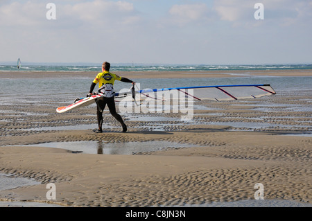 Windsurfer sur West Wittering plage à marée basse, son laquer pour voile près de Chichester, West Sussex, Angleterre Banque D'Images