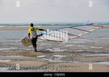 Windsurfer sur West Wittering plage à marée basse, son laquer pour une voile, près de Chichester, West Sussex, Angleterre Banque D'Images