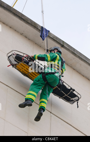 Ambulancier paramédical est ramené vers le bas d'un bâtiment sur une corde avec un patient pendant le lancement de l'Irlande du Nord Ambulance Service (NIAS) Équipe d'intervention en zone dangereuse (HART). Banque D'Images